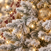 Detalle de ramas nevadas y luces cálidas del árbol de Navidad Abete Nevos