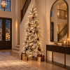 Árbol de Navidad Abete Nevos nevado con luces en recibidor elegante