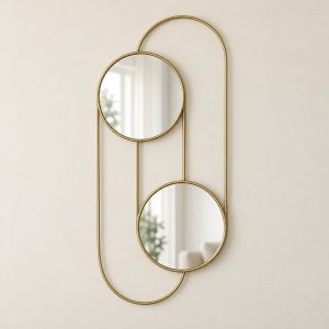 Espejo de pared doble Duo Hublots con estructura dorada vertical sobre fondo beige