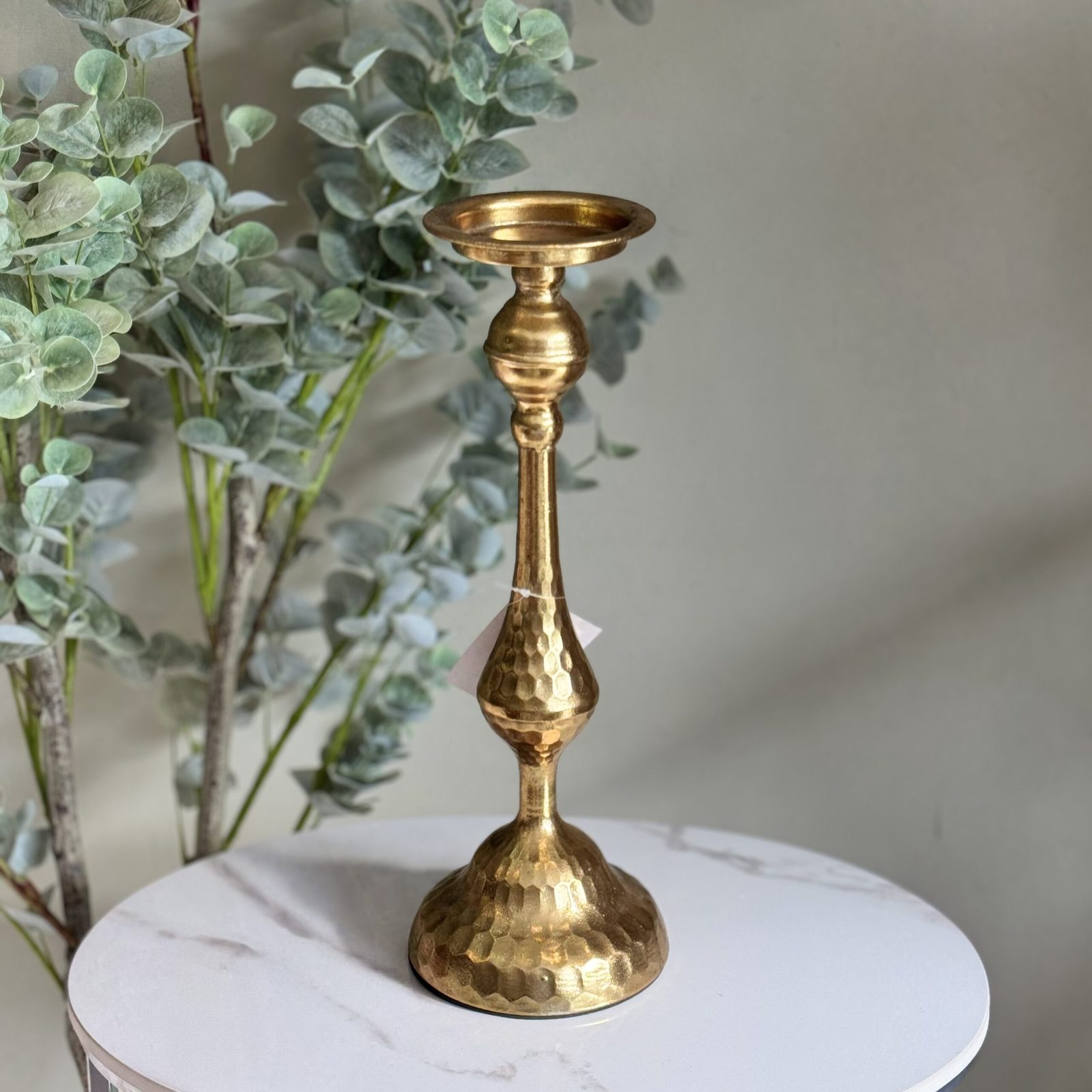 Candelabro de metal con acabado dorado martillado.