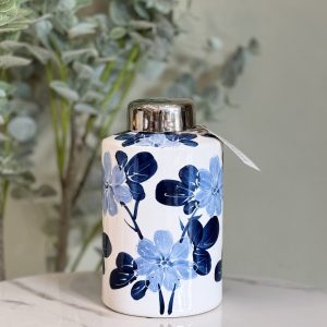 Ánfora de cerámica con tonos blancos y diseños azules.